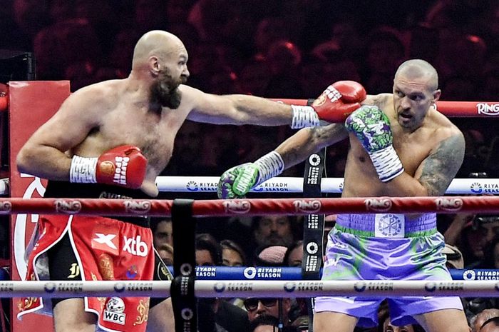 Tyson Fury dari Inggris (merah) dan Oleksandr Usyk dari Ukraina (biru) bertanding dalam pertandingan ulang gelar juara dunia di Kingdom Arena di Riyadh pada 22 Desember 2024.