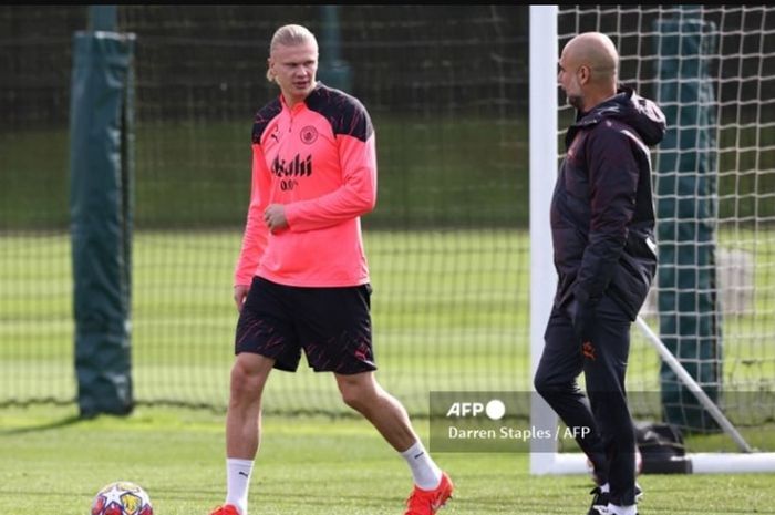 Pelatih Man City, Pep Guardiola, berbicara dengan Erling Haaland dalam sesi latihan di markas latihan tim, Etihad Campus.