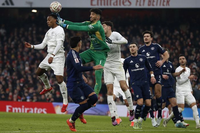 Altay Bayindir mencoba menghalau bola dari Jurrien Timber dalam duel sengit Arsenal vs Man United pada ronde ketiga Piala FA di Stadion Emirates, London (12/1/2025).