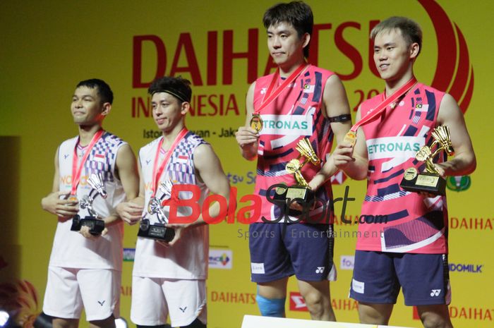 Fajar Alfian/Muhammad Rian Ardianto (kiri) berdiri di podium bersama Man Wei Chong/Kai Wun Tee (kanan) dari Malaysia setelah final Indonesia Masters 2025.