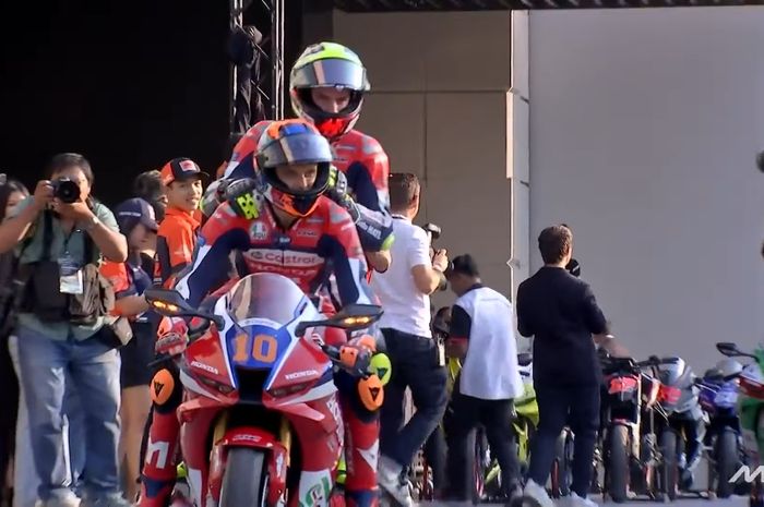 Pembalap Honda HRC Castrol, Joan Mir, membonceng rekan setimnya, Luca Marini, dalam acara MotoGP Season Launch 2025 di Bangkok, Thailand, 9 Februari 2025.