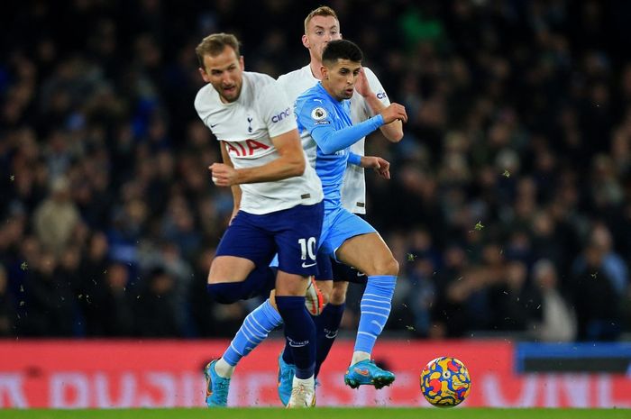 Harry Kane (kiri) berduel dengan Joao Cancelo dalam laga Man City kontra Tottenham Hotspur di Liga Inggris, 19 Februari 2022 di Etihad Stadium.