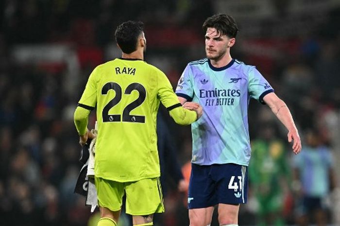 Declan Rice (kanan) dan David Raya bersalaman setelah laga Man United vs Arsenal di Old Trafford kelar (9/3/2025). Gagal pecundangi United, The Gunners disebut harus menyerah saja dalam perlombaan juara Liga Inggris dengan Liverpool.
