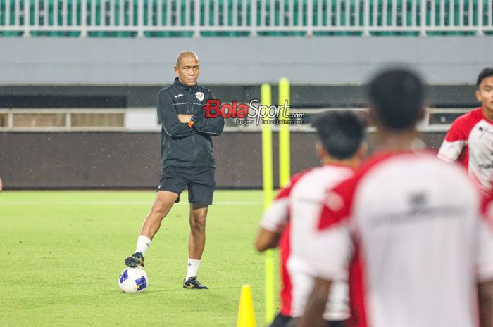 Pelatih timnas U-17 Indonesia, Nova Arianto (kiri), sedang memantau para pemainnya berlatih di Stadion Pakansari, Bogor, Jawa Barat, Kamis (13/3/2025).