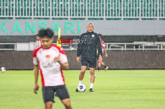 Pelatih timnas U-17 Indonesia, Nova Arianto (kanan), sedang memantau para pemainnya berlatih di Stadion Pakansari, Bogor, Jawa Barat, Kamis (13/3/2025).