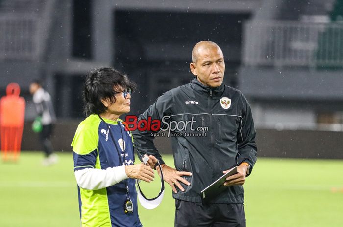 Pelatih timnas U-17 Indonesia, Nova Arianto (kanan) dan Fisioterapis timnas U-17 Indonesia, Choi Ju-young (kiri), sedang memantau para pemainnya berlatih di Stadion Pakansari, Bogor, Jawa Barat, Kamis (13/3/2025).
