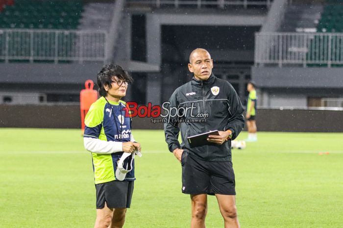 Pelatih timnas U-17 Indonesia, Nova Arianto (kanan) dan Fisioterapis timnas U-17 Indonesia, Choi Ju-young (kiri), sedang memantau para pemainnya berlatih di Stadion Pakansari, Bogor, Jawa Barat, Kamis (13/3/2025).