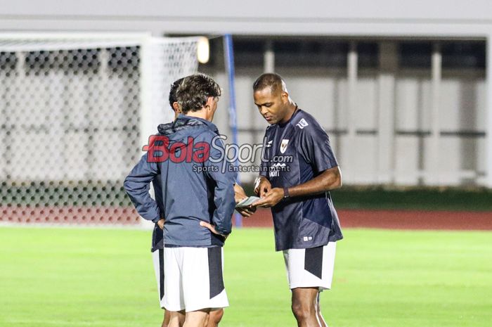 Pelatih Timnas Indonesia, Patrick Kluivert (kanan), sedang berdiskusi dengan asistennya saat memantau para pemainnya berlatih di Stadion Madya, Senayan, Jakarta, Minggu (23/3/2025).
