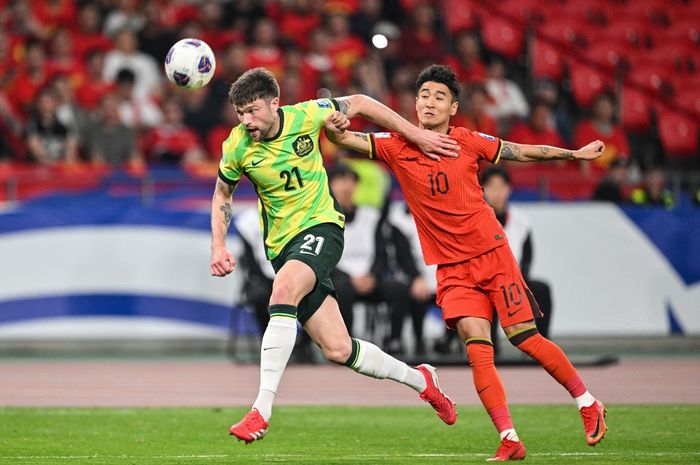 Pemain Australia Cameron Burgess (kiri) berebut bola dengan pemain China, Wei Shihao selama pertandingan kualifikasi Piala Dunia 2026 antara China Vs Australia di Stadion Pusat Olahraga Olimpiade Hangzhou di Hangzhou, provinsi Zhejiang, Tiongkok timur pada tanggal 25 Maret 2025.