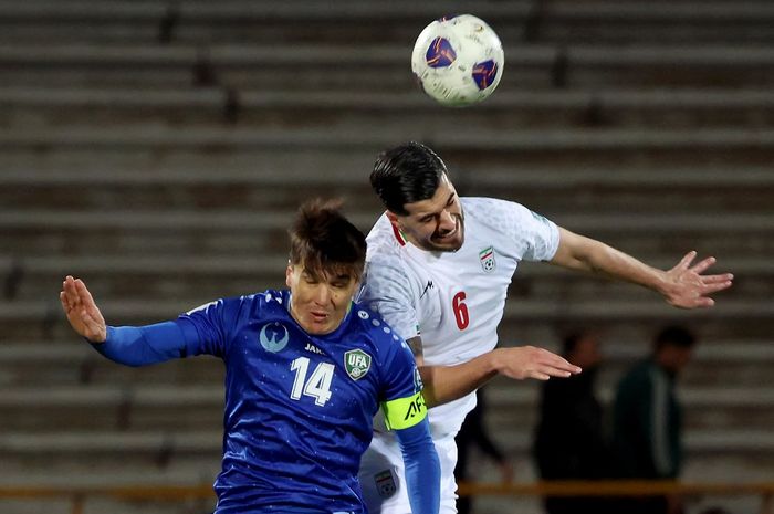 Pemain Iran, Saeed Ezatolahi (kanan), berduel dengan striker Uzbekistan, Eldor Shomurodov dalam laga Kualifikasi Piala Dunia 2026 Zona Asia di Teheran, Selasa (25/3/2025).