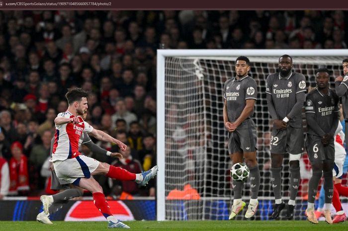 Momen gelandang Arsenal, Declan Rice, mencetak gol via tendangan bebas ke gawang Real Madrid pada leg pertama perempat final Liga Champions 2024-2025.