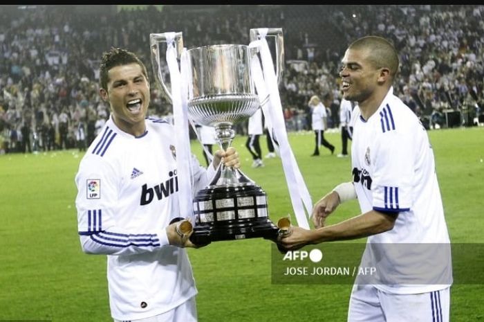 Cristiano Ronaldo (kiri) meraih gelar Copa del Rey 2010-2011 sebagai trofi perdananya untuk Real Madrid usai mengalahkan Barcelona di final.