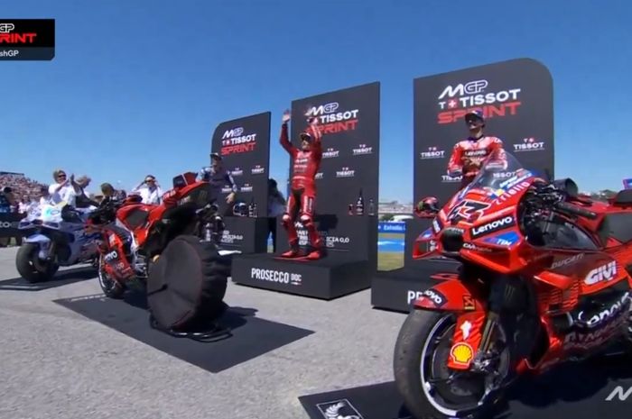 Francesco Bagnaia (kanan) ikut bertepuk tangan saat Marc Marquez dan Alex Marquez bersorak bersama pendukung di atas podium sprint race MotoGP Spanyol 2025 di Sirkuit Jerez, Spanyol, Sabtu (26/4/2025).
