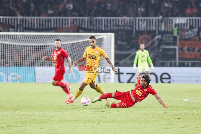 Hansamu Yama Pranata (kanan) sedang menekel bola yang dikuasai Bruno Gomes De Oliveira Conceicao (tengah) dalam laga pekan ke-30 Liga 1 2024/2025 antara Persija Jakarta versus Semen Padang di Stadion Pakansari, Bogor, Jawa Barat, Minggu (27/4/2025) malam.