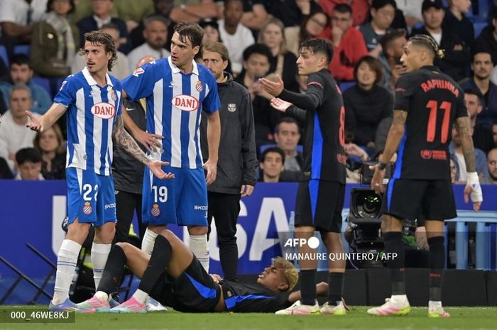 Winger Barcelona Lamine Yamal (bawah) tergeletak di lapangan setelah dilanggar oleh bek Espanyol Leandro Cabrera.