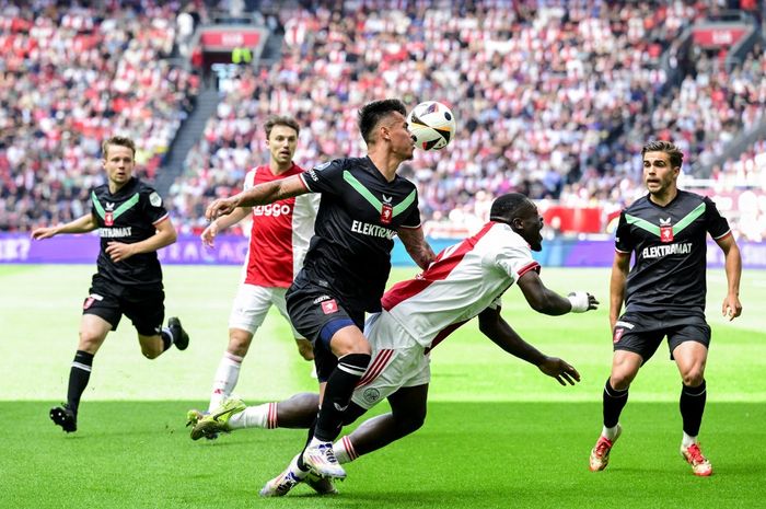 Bek Twente dan Timnas Indonesia, Mees Hilgers (kiri), melakukan pelanggaran kepada pemain Ajax, Brian Brobbey, dalam laga Liga Belanda pada Minggu (18/5/2025) di Amsterdam.
