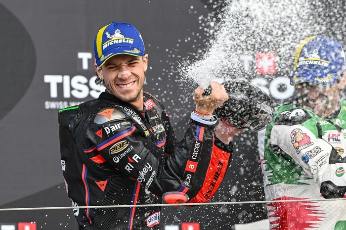 Pembalap Aprilia Racing, Marco Bezzecchi, berselebrasi di podium usai memenangkan balapan MotoGP Inggris 2025