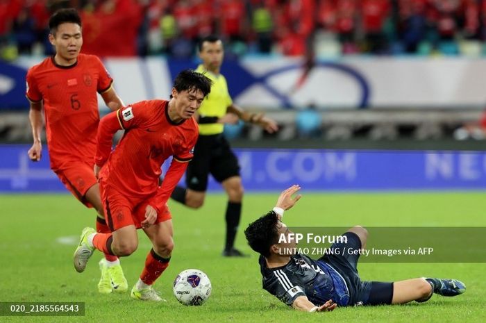 Pemain Timnas China, Hu Hetao (tengah), berduel dengan gelandang Timnas Jepang Wataru Endo.