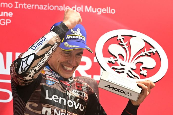 Pembalap Ducati Lenovo, Marc Marquez, berpose dengan trofi juara MotoGP Italia 2025 di Sirkuit Mugello, Minggu (22/6/2025).