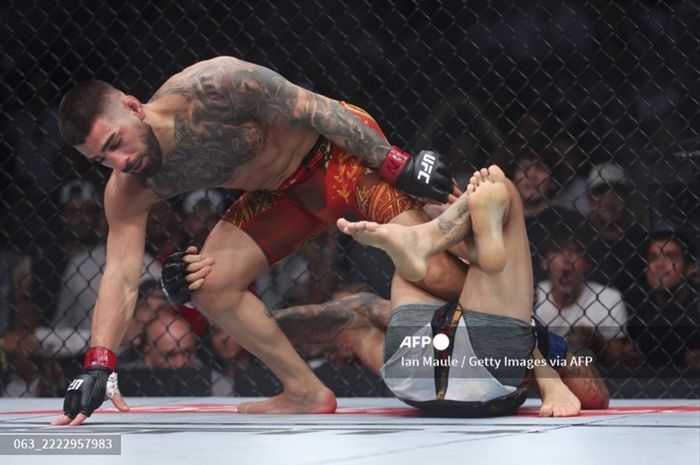 Ilia Topuria menjauhi Charles Oliveira yang sudah dinyatakan kalah KO pada UFC 317 Sabtu di T-Mobiile Arena, Las Vegas, Nevada, Amerika Serikat atau Minggu (29/6/2025) waktu Indonesia.