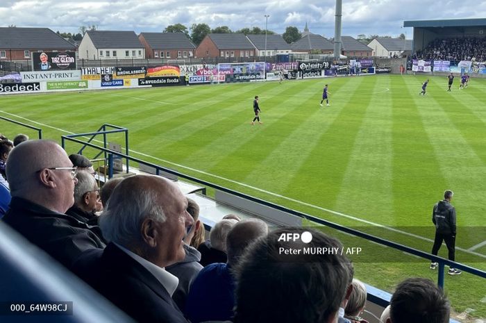 Para pendukung termasuk mantan pemain Glenavon FC, John Duggan, menyaksikan pertandingan mantan timnya melawan FC Erzgebirge Aue yang tertunda selama 65 tahun karena Perang Dingin.