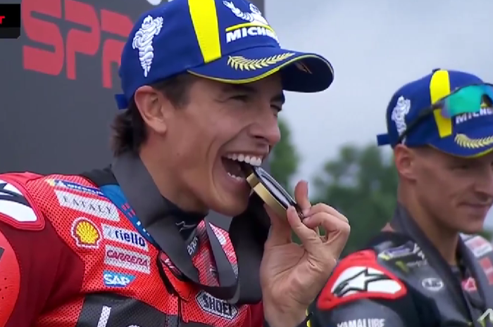 Pembalap Ducati, Marc Marquez, menggigit medali setelah memenangi sprint race MotoGP Jerman 2025 di Sachsenring, Sabtu (12/7/2025).