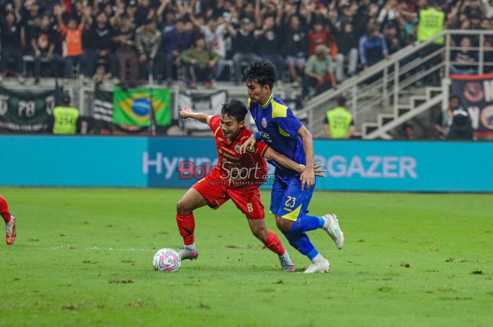 Witan Sulaeman (kiri) sedang menguasai bola dan dibayangi Muhammad Anwar Rifa'i (kanan) dalam laga uji coba Persija Jakarta versus Arema FC di Jakarta International Stadium (JIS), Jakarta Utara, Sabtu (26/7/2025).