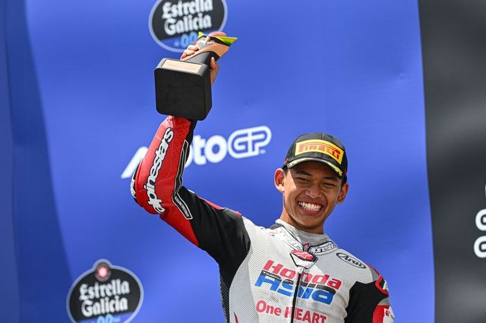 Pembalap Indonesia, Veda Ega Pratama, mengangkat trofi pertamanya di podium setelah finis ketiga dalan balapan Moto3 Brasil 2026 di Sirkuit Ayrton Senna, Brasil, Minggu (22/3/2026).