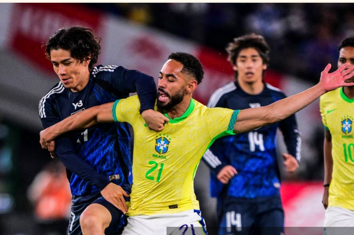 Ao Tanaka (kiri) berebut bola bersama Matheus Cunha pada laga uji coba timnas Jepang melawan Brasil di Tokyo (14/10/2025). Kedua tim akan kembali bertemu di babak 32 besar Piala Dunia 2026.