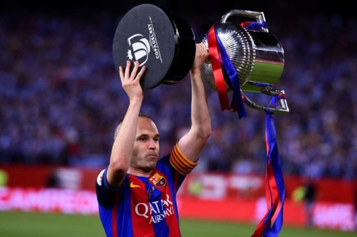 Kapten Barcelona, Andres Iniesta, mengangkat trofi Copa del Rey setelah timnya memenangi final kontra Deportivo Alaves di Stadion Vicente Calderon, 27 Mei 2017.