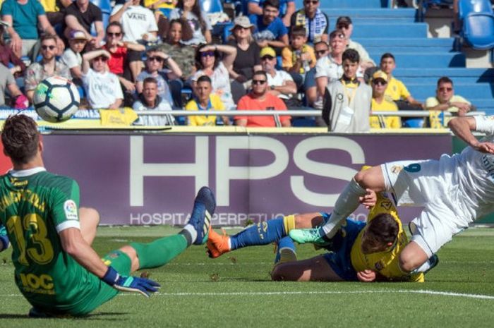 Penyerang Real Madrid, Karim Benzema, berduel dengan bek Las Palmas pada laga Liga Spanyol di Stadion de Gran Canaria, Sabtu (31/3/2018).