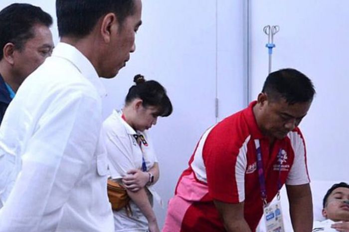 Presiden Joko Widodo saat mendatangi Anthony Sinisuka Ginting yang cedera saat bertanding melawan Shi Yuqi pada partai pertama, final beregu putra Indonesia vs China di Istora Gelora Bung Karno, Jakarta, Rabu (22/8/2018).