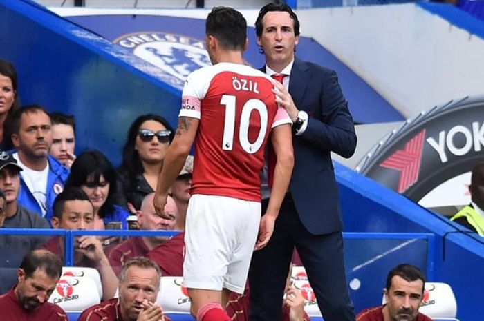 Pelatih Arsenal Unai Emery berbicara dengan Mesut Oezil dalam partai Liga Inggris di markas Chelsea, Stadion Stamford Bridge, Sabtu (18/8/2018) malam WIB.