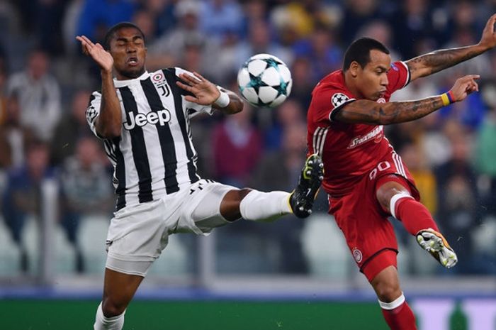 Pemain Juventus, Douglas Costa (kiri), berduel dengan gelandang Olympiacos, Felipe Pardo, dalam laga Grup D Liga Champions di Juventus Stadium, Turin, Italia, pada 27 September 2017.