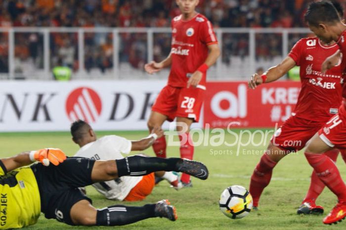   Kiper Persija, Andritany Ardhiyasa (kuning) terjatuh dan dua rekannya mengamankan bola dari serbuan pemain Borneo FC pada laga pekan keempat Liga 1 2018 di SUGBK, Sabtu (14/4/2018).   