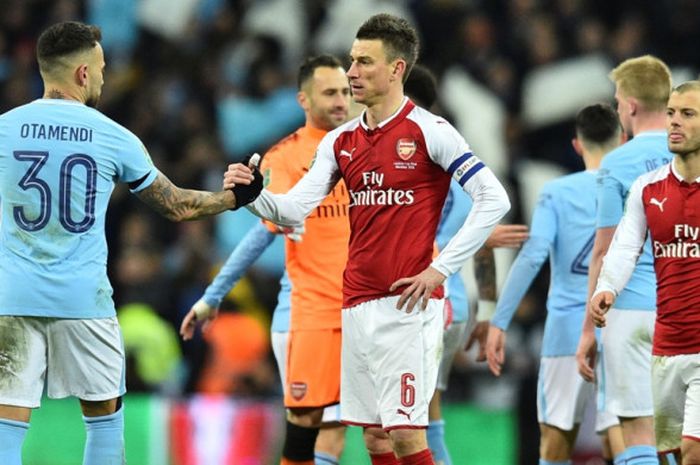 Kapten Arsenal, Laurent Kocielny (tengah), bersalaman dengan bek Manchester City, Nicolas Otamendi, seusai laga final Piala Liga Inggris di Stadion Wembley, London, pada 25 Februari 2018.