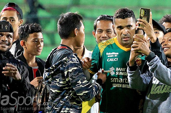   Striker Sriwijaya FC, Alberto Goncalves, disambut penggemarnya untuk diajak berswafoto usai laga melawan Perseru Serui pada pekan ke-11 Liga 1 2018 di Stadion Gajayana Malang, Jawa Timur, Minggu (27/05/2018) malam.  