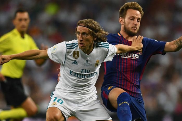 Gelandang Real Madrid, Luka Modric (kiri), berduel dengan pemain FC Barcelona, Ivan Rakitic, dalam laga Piala Super Spanyol di Stadion Santiago Bernabeu, Madrid, pada 16 Agustus 2017.