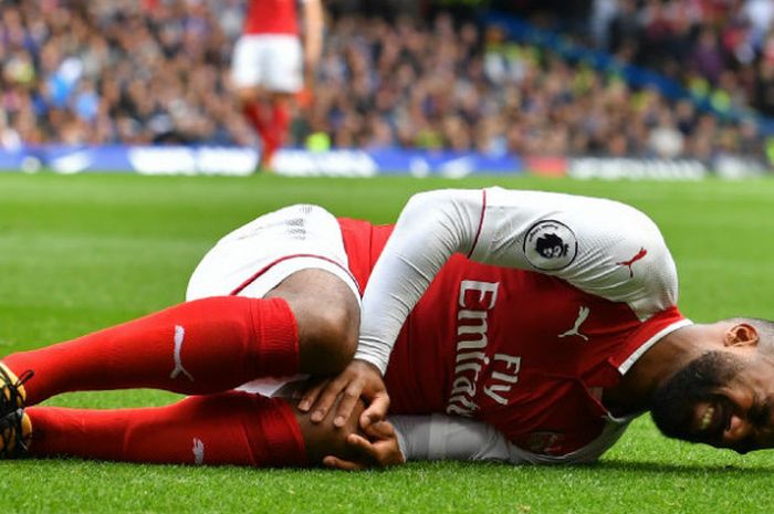 Striker Arsenal, Alexandre Lacazette, mengerang kesakitan seusai dilanggar pemain Chelsea dalam laga di Stamford Bridge, Minggu  (17/9/2017).