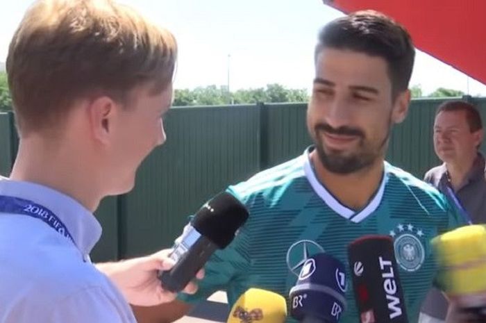 Gelandang timnas Jerman, Sami Khedira, memberi senyuman pada reporter media Swedia Expressen yang menyodorkan tiket pulang untuknya.