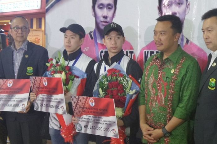 Juara All England 2017, Marcus Fernaldi Gideon/Kevin Sanjaya Sukamuljo, berfoto dengan Menteri Pemuda dan Olahraga Republik Indonesia (Menpora RI) Imam Nahrawi seusai menerima bonus secara simbolis di Terminal Kedatangan 2E Bandara Soekarno-Hatta, Tangerang, Banten, Selasa (14/3/2017) petang WIB.