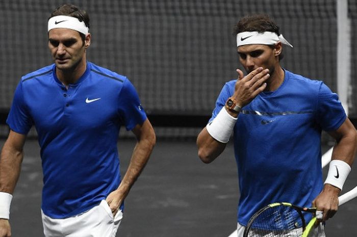     Rafael Nadal (kanan) dan Roger Federer berbisik-bisik saat menjalani laga ganda putra Piala Laver di Praha, Republik Ceska, Sabtu (23/9/2017).    