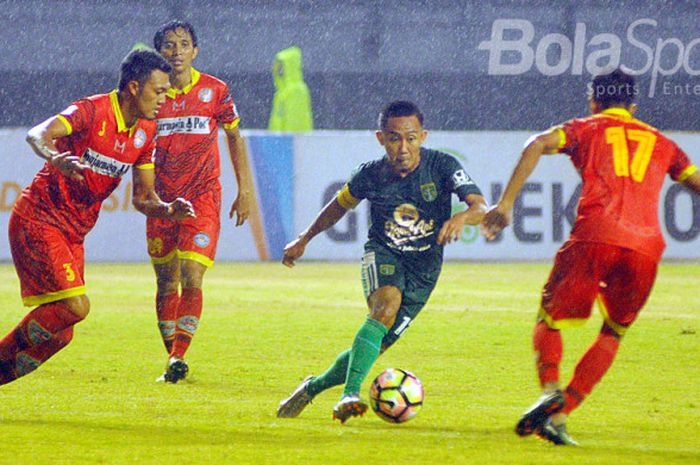 Pemain senior Persebaya, Rendi Irwan dikepung tiga pemain Martapura FC pada pertandingan di Gelora Bung Tomo Surabaya, Kamis (27/7/2017) malam.