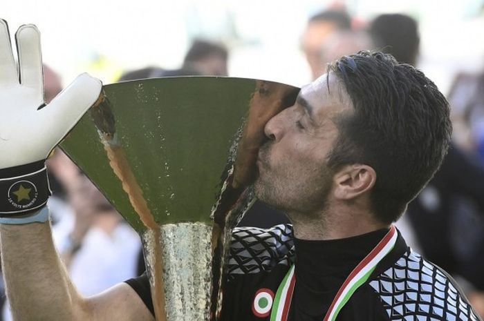 Kiper Juventus, Gianluigi Buffon, mencium trofi juara usai kemenangan 3-0 atas Crotone pada laga Serie A di Juventus Stadium, Turin, 21 Mei 2017.