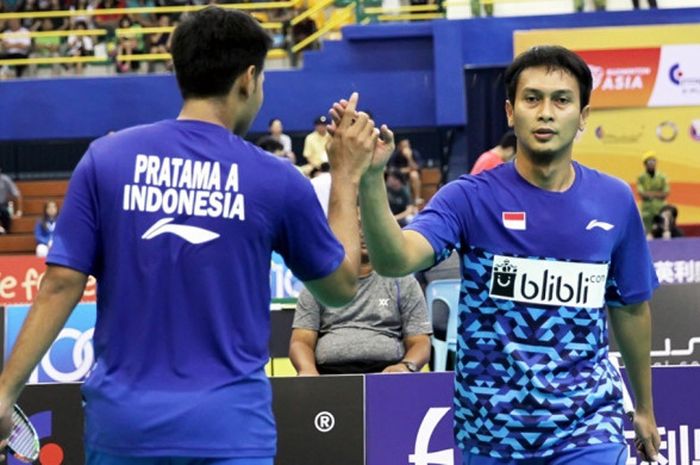 Pasangan ganda putra Indonesia, Mohammad Ahsan (kanan)/Angga Pratama, melakukan tos seusai meraih poin atas lawan mereka, Chung Eui-seok/Seo Seung-jae (Korea Selatan), pada laga semifinal Kejuaraan Beregu Asia 2018 di Stadium Sultan Abdul Halim, Alor Setar, Kedah, Malaysia, Sabtu (10/2/2018).