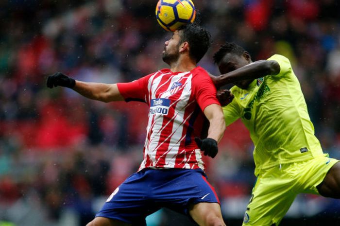 Diego Costa berebut bola dengan Dakonam Djene saat Atletico Madrid menjamu Getafe pada pertandingan La Liga di Wanda Metropolitano, Sabtu (6/1/2018).