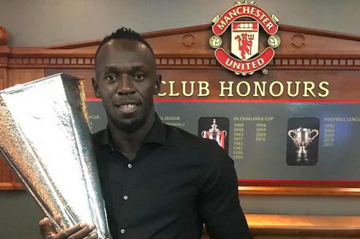 Sprinter Jamaika, Usain Bolt, saat berpose dengan piala UEFA Europa League milik Manchester United