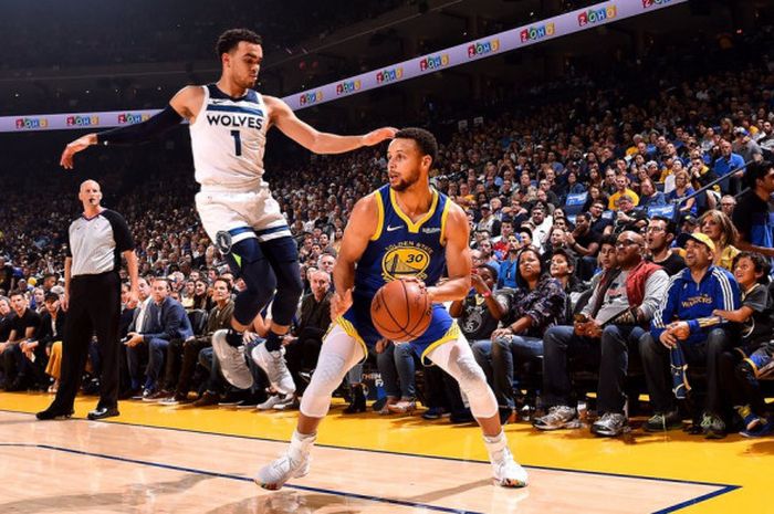 Pemain Golden State Warriors, Stephen Curry (jersey biru #30), saat melakukan fake shot terhadap pem