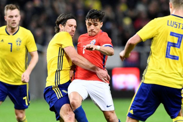 Penyerang Cile, Alexis Sanchez (tengah) mencoba melewati barisan pemain Swedia dalam laga uji coba di Friends Arena, Solna, 24 Maret 2018.