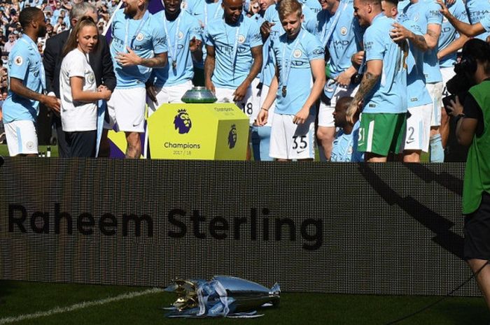 Trofi Liga Inggris tanpa disengaja terjatuh saat Manchester City merayakan gelar juara usai bertanding melawan Huddersfield Town di Stadion Etihad, Minggu (6/5/2018).